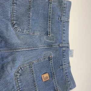 1990 vintage Carhartt Carpenter Pants  - Hej, Säljer mina carhartt jeans då de är för stora för mig. De är dock mycket fina. På baksidan hade de hål som fixats av en sömerska. Det finns även en liten fläck på knät.  Midja: 34 tum, 89cm Innerbenslängd: 74cm Ytterbenslängd: 108cm