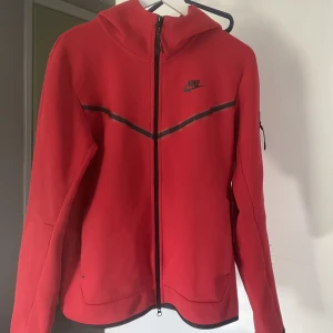 Nike tech fleece  - Jag säljer nu min röda nike tech fleece pga den inte kommer till användning då den är för stor för mig. Väldigt bra skick och använd fåtal gånger. Ända tecknet av användning ser ni på bild 3. Skriv för frågor eller fler bilder💞Pris kan diskuteras 