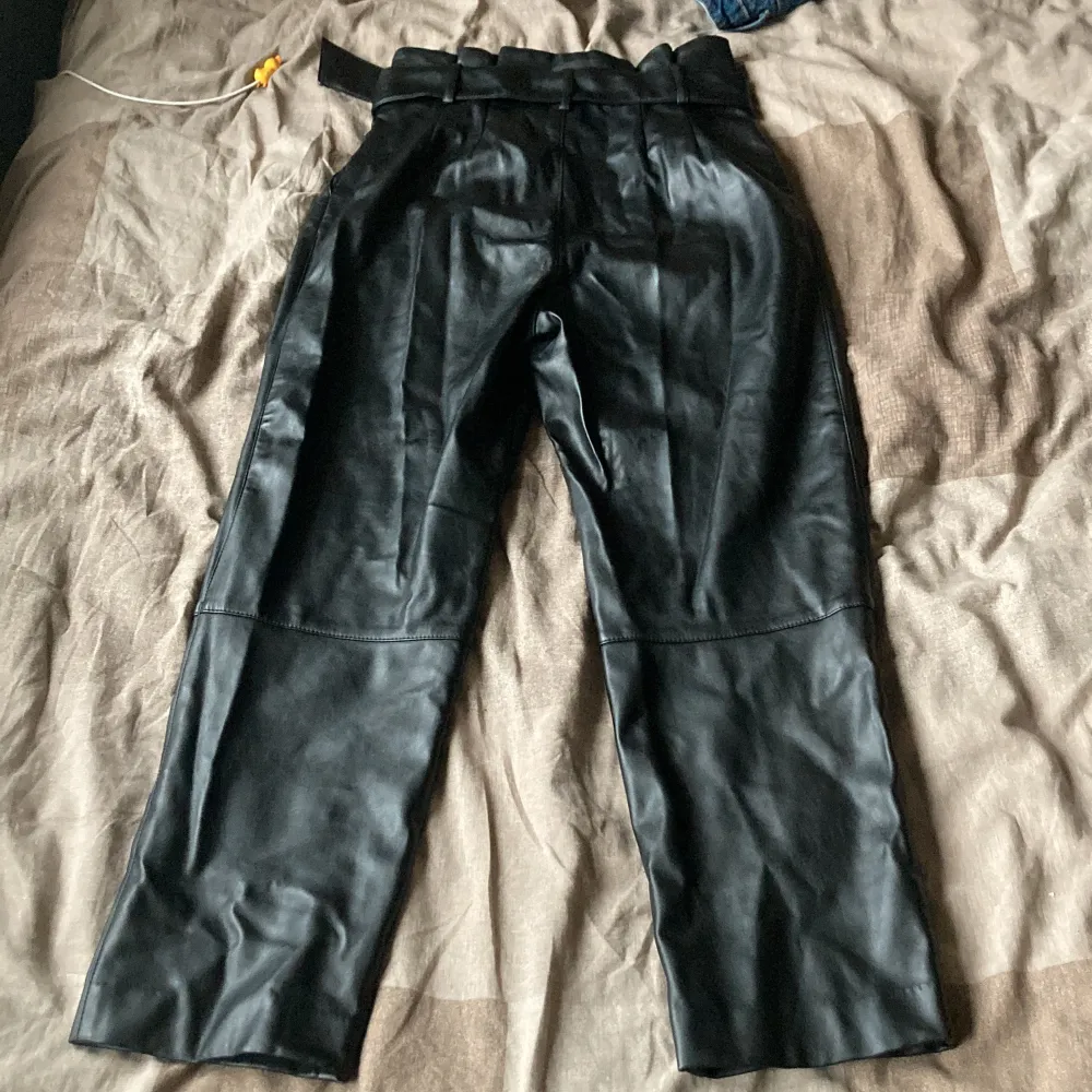 Highwaisted Kostymbyxor i fuskskinn med skärp. Innerbenslängd 66 cm.. Jeans & Byxor.