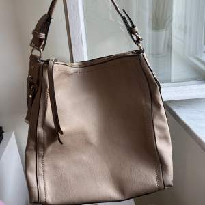 Superfräsch väska från märket Oasis (köpt på accent)! Rymlig med bra fickor och i en brun/beige färg. 