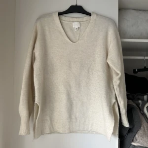 Stickad beige  - Fin stickad tröja som är lite mer oversized i modellen, endast använd 1 gång!! Därav fint skick. Storlek XS men passar också S-M. Har slits på båda sidor. Jättefint! 