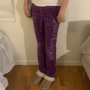 Juicy Couture byxor äldre modell - Lila Juicy Couture byxor. Äldre modell, lite blekta på knäna men inget man tänker på. Annars inga tecken på användning. Storlek XS, perfekt i längden för mig som är 169cm.