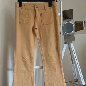 Bootcut jeans - Orangea bootcut jeans som tyvärr inte passar mig. De är lågmidjade och har en orange/senapsgul snygg färg med snygga detaljer! Storleken skulle jag säga är 34/36 bud från 290kr