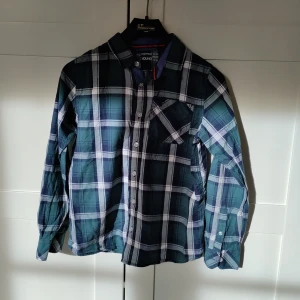Skjorta - Grön och blårutig skjorta. Använd många gånger med fortfarande i väldigt fint skick. Säljer eftersom den är för liten.