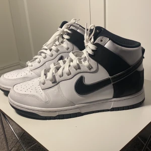 Snygga dunks i stl 43 - Vita Nike dunk high i vit med svarta detaljer. Använda ett fåtal ggr - som nya! Stl 43.