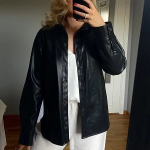 Skjortjacka - Säljer min skjortjacka i skinnimmitation 💓 jackan är sparsamt använd och har inga eller få defekter 💋jackan är svart med bruna knappar och i storlek S ✨💓jackan är köpt på gekås 