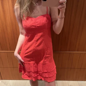 Denim klänning - Röd denim klänning med volanger nedtill. Storlek 38.