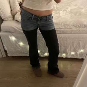 Två färgade jenas Lågmidjade  - Lågmidjade jenas i två färger  Storlek 25/32, men passar mer 27/32 då jag har 27 i vanliga fall och de passar mig perfekt Byxorna är mörkgråa och blåa och har mycket stretch  Midjemåttet är 37cm  Ytterbenslängden är 101cm 