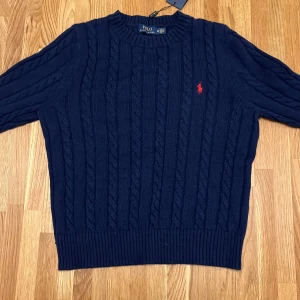 Ralph Lauren stickad tröja - Ändast testad så nästan helt ny. Perfekt skick. MÖRK BLÅ DAM RALPH LAUREN STICKE TRÖJA. Kvitto finns.   NY PRIS: 1999  MITT PRIS: 750
