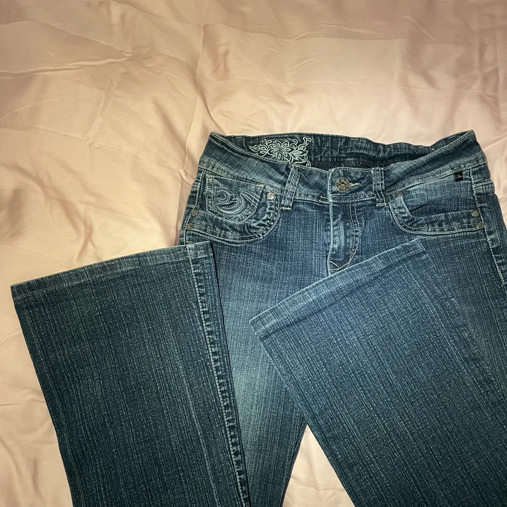 Mörkblå jeans i ett perfekt skick med jättecoola detaljer 💕 sitter lågmidjade och bootcut! Säljer för att de tyvärr är för korta på mig🥹. Jeans & Byxor.