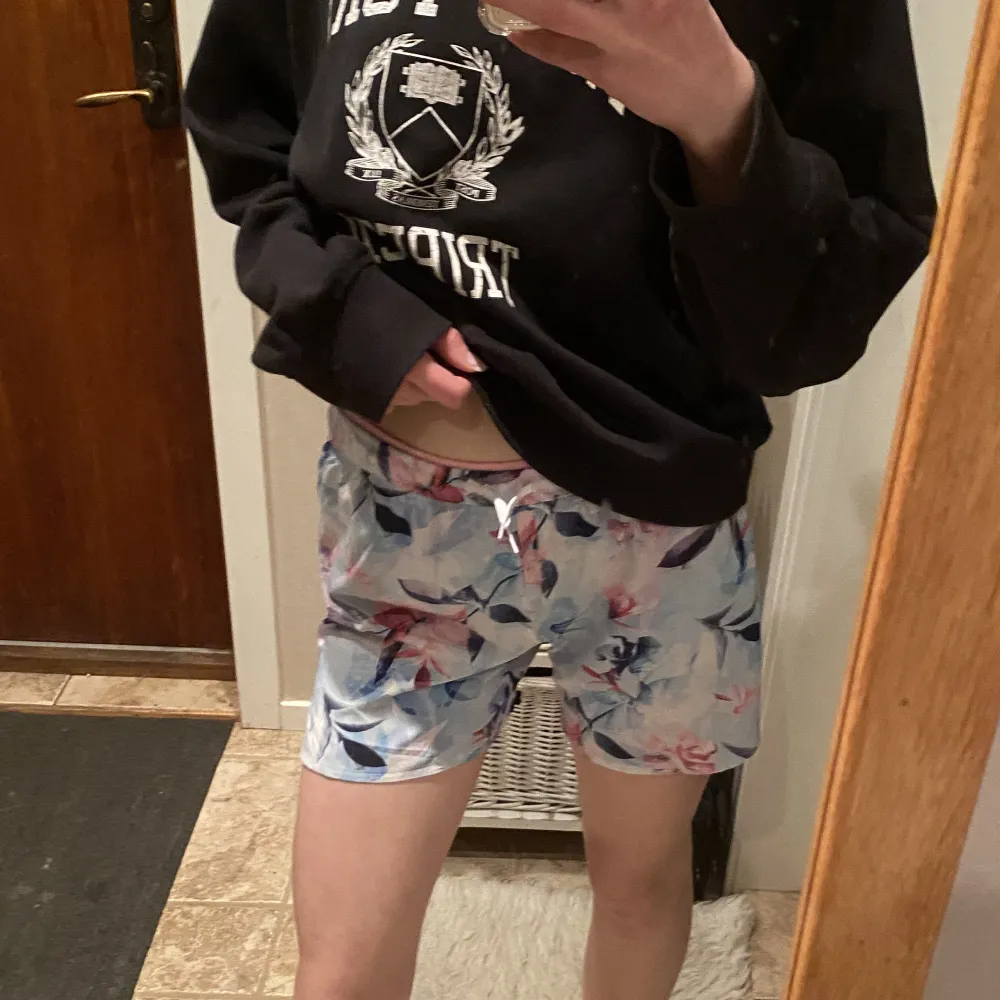 Blåa träningsshorts med blommor på och har ett rosa midjeband på insidan från Soc💕Använda ca 5 gånger och har inga fel. Strl. 158/164 men passar också XS.. Shorts.