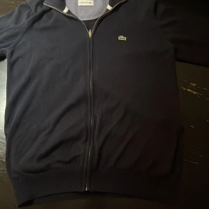 Lacoste full zip  - Säljer nu min Lacoste full zip då den inte används, mycket bra skick inget nopprig eller liknande. Säljs då den inte används