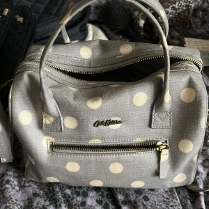 Cath Kidston - Prickig väska använd många gånger, den har några mindre fläckar och bandet är lite slitet samt ena dragkedjan, men annars i gott skick. 