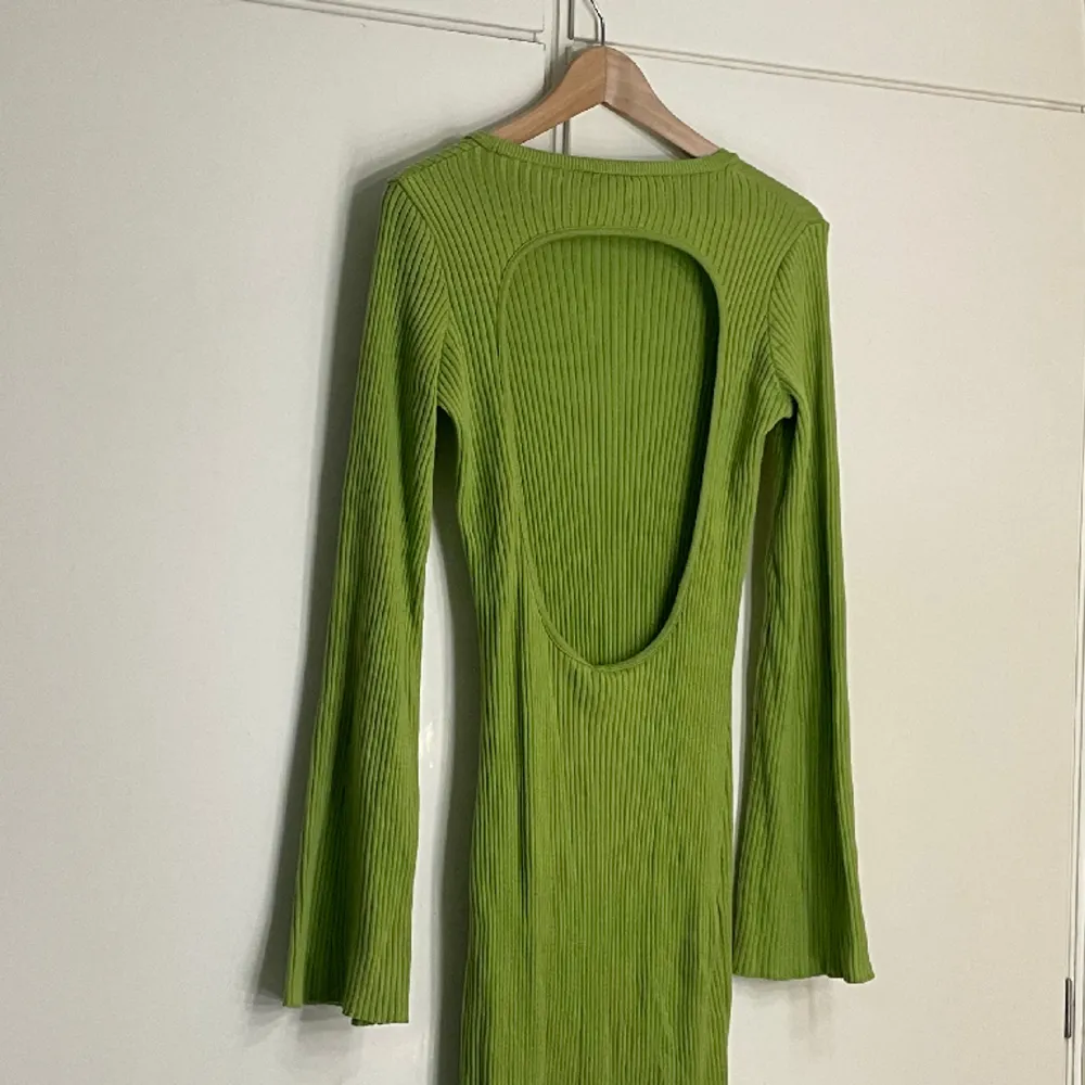 Lång grön stickad klänning från NA-KD, klockade ärmar, öppen rygg o vacker siluett. Använd enstaka gånger. Storleken är M, skriv för exakta mått. Pris diskuterbart!❤️. Klänningar.