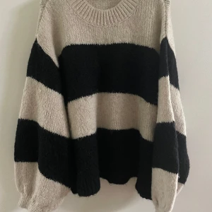 Mysig stickad tröja fr Gina Tricot - Supermysig, varm stickad tröja, beige och svartrandig, stl xl. Knappt använd, toppskick! Nypris 499:-