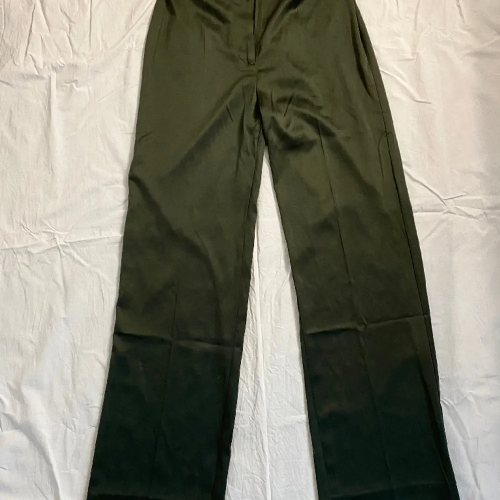 mörkgröna kostymbyxor i satin från envii, insydda då dom är för stora på mig, lätt att ta upp. midja: 36cm innerben: 82cm. Jeans & Byxor.