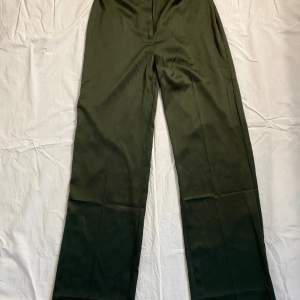 mörkgröna kostymbyxor i satin från envii, insydda då dom är för stora på mig, lätt att ta upp. midja: 36cm innerben: 82cm