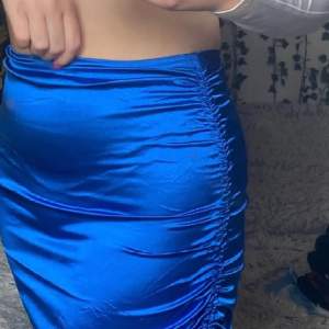 Kort blå kjol med snöre på sidan
