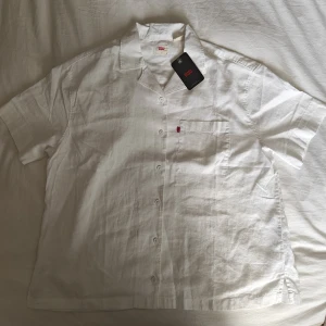 Linne Levi's skjorta - Helt ny linne Levi's skjorta. Oversized. Längden på den är normal men den är bred. Material: 55% Bomull, 45% Linne. Köpt i Italien. Jag säljer den eftersom jag köpte två styckna och behöver bara en. Jätte fint skick, aldrig använd. Prislappen är på.