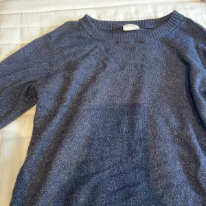 Stickad tröja - En stickad mörkblå tröja med vita detaljer inuti. Den är mjuk och skön! 