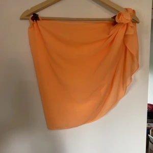 Orange sarong - Ej använd. Bara att dra på över bikinin. Eller ha i håret. 
