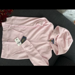 Rosa Ralph Lauren-hoodie stl 12-14 år  - Oanvänd rosa hoodie/luvtröja från Ralph Lauren. Aldrig använd pga felköp.  Nypris ca 1500 kr.  Nu 300 kr 