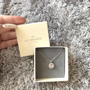Lily and rose halsband - Säljer ett silvrigt diamant halsband från Lily and rose, med en ljusrosa diamant. Aldrig använd, så nytt. Säljs pga att jag fick dubbletter i present.