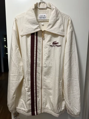 Jacka / tröja från Lacoste  - Säljer en frän Ricky regal jacka. Jackan är ett samarbete med Bruno mars och Lacoste, och var sjukt svår att få tag på. Den säljs ej längre och många som söker kläderna han släppte i liten upplaga.  Snygga guld detaljer och vinröda ränder.  Storlek: L