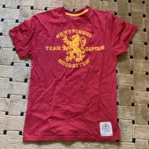 Röd Harry Potter Quidditch t-shirt S - Köpt på Harry Potter World i London och sparsamt använd. Strl S i ett tjockt t-shirt tyg med snyggt tryck.
