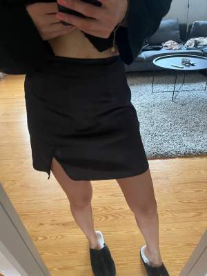 Svart kjol i typ satin, knappt använd, storlek xs, från shein