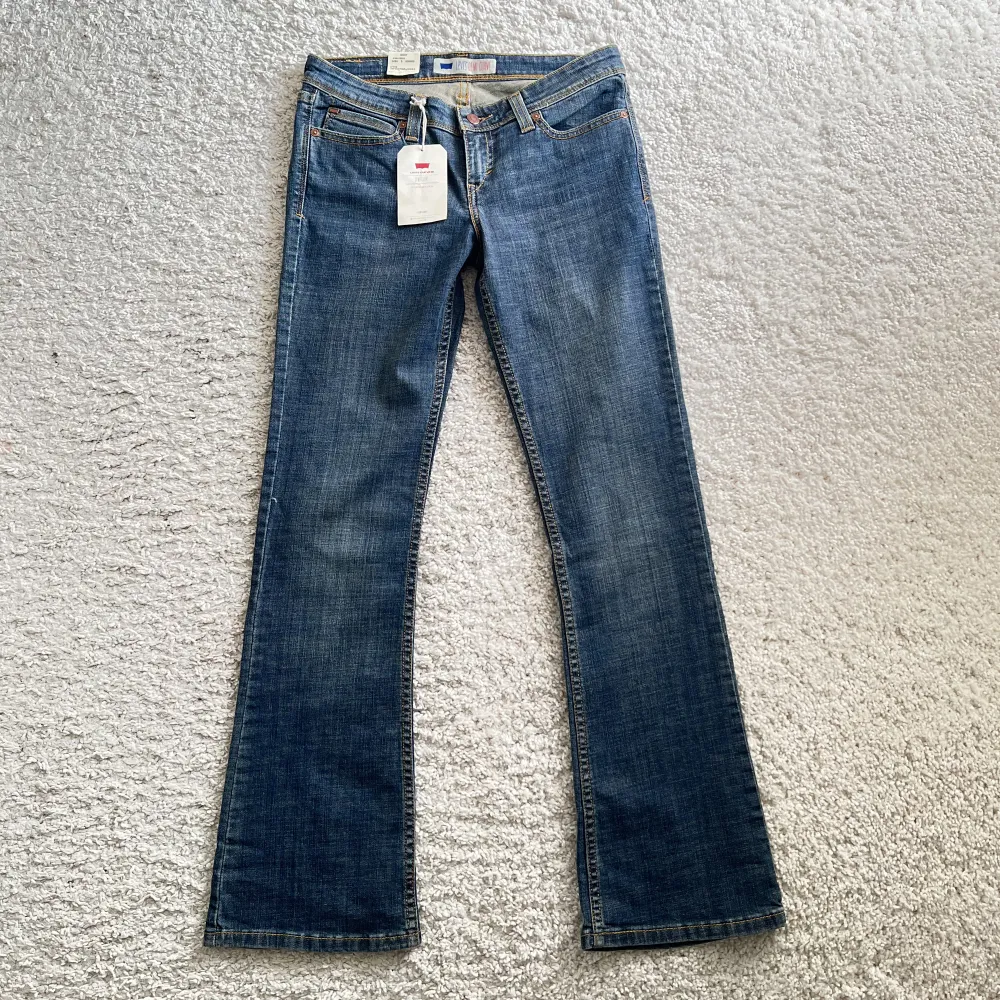 Superfina Levis bootcut low rise jeans med coola detaljerade fickor. Storlek 29, passar mig som brukar ha storlek S! De är helt nya med lapparna kvar! Långa för mig som är 164!. Jeans & Byxor.