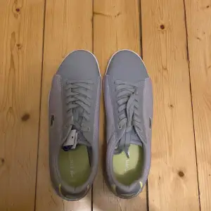 Säljer ett par snygga sneakers från Lacoste. Helt nya och lappen sitter kvar. Givetvis äkta. Storlek 40. 