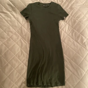 Miniklänning - Kort klänning i rubbat material. Säljer även i svart. Klänningen formar sig efter kroppen och är då inte lika rak som den ser ut på bilden