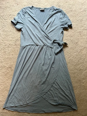 Omlottklänning från Vila  - Använd 2-3 gånger, tycker inte den sitter fint på mig.  Den går ungefär till knät. 