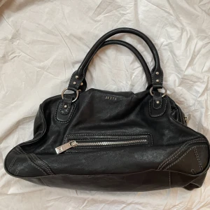 Väska - Väska från jette med silver detaljer i nyskick, flera fack på insidan och baksida. Vill du köpa trycker du på ”köp nu” jag postar alltid samma dag eller dagen köp. Snabbast leverans med PostNord 