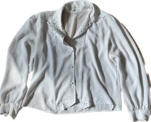 Skjorta  - Blus/skjorta, lite kroppad, med blommiga detaljer. 