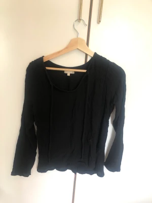 Svart blus - Säljer en fin svart blus köpt secondhand och är i storlek M män passar även bra på mig som har xs/s. 