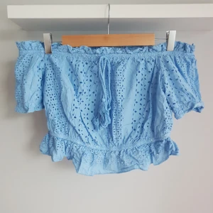 Croppad topp - Ljusblå croppad topp med puffiga ärmar och knytning framtill. Något liten i storleken. Har aldrig blivit använd och är i ett bra skick.