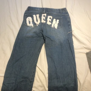 Jeans - Blåa vida jeans med text på rumpan