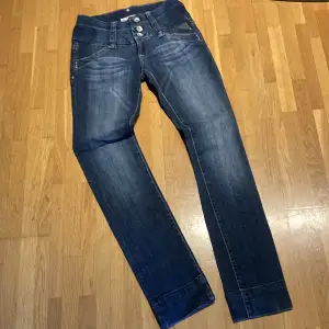 Stretch jeans med bred linning  Både tre knappar och liten dragkedja 