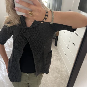 Stickad kortärmad kofta  - Jättte snygg kortärmad kofta som är perfekt till hösten. Man kan ha den både öppen och stängd! 