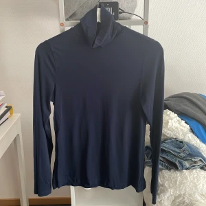 Polotröja långärmad - Mörkblå långärmad polotröja i använt skick! Ca 7 år gammal. Inga hål eller lagningar. 95 % viskos och 5 % elastan. Perfekt baströja!