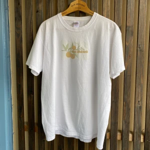 Vit T-shirt  - Vit T-shirt från Fruit of the Loom i storlek M/L med tryck ”GOOD VIBRATIONS”. Pris: 79kr. 