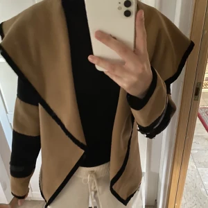 Jacka  - Intressekoll på jacka i beigebrun färg med svarta detaljer. I nyskick. Säljes pga flytt.