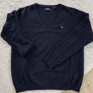 Gant stickad tröja - Marinblå v-ringad tröja i fint skick. Gant har små storlekar vilket gör att denna XL är som en L och då sitter den mer tajt. En M lite lösare. Inköpt för 1000 kr. 