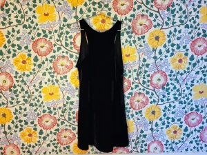 Förklädesklänning - Förklädesklänning i svart sammet, fin över exempelvis en vit skjorta. Inget märke, i gott skick. Uppskattad storlek onesize, eftersom den är mjuk och stretchig passar den fler kroppstyper.