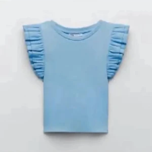 Zara topp - Zara topp med volangärm, ljusblå. Bra skick. Ser missfärgad ut på bilden men det är ljuset.