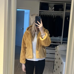 Pälsjacka  - Pälsjacka med luva. Använd en gång. Säljs inte längre. Gul orange färg. Nypris 600kr