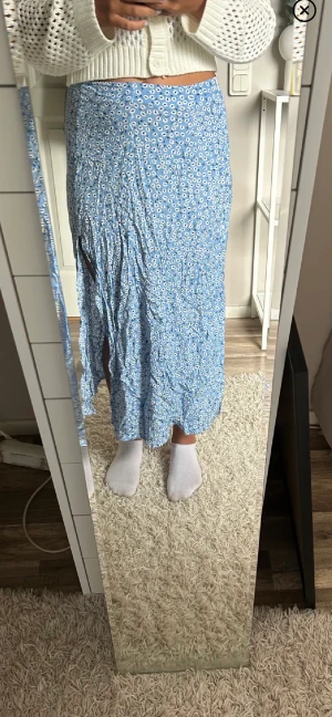 Kjol - En kjol med slits, har ett litet hål nedanför kardan men märks knappt