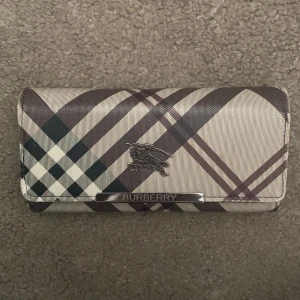 Burberry plånbok  - En fin plånbok i fint skick med mycket plats och olika fickor, för sedlar, mynt och kort. Kan skicka bilder på insidan vid intresse.